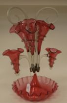 An Edwardian Cranberry glass epergne with frilled borders, comprising a series of six trumpets and