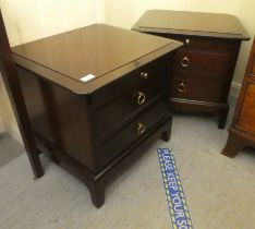 A pair of Stag mahogany finished dressing chests, each with a slide, over two drawers, raised on