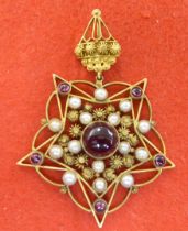 A yellow metal star design pendant, set with garnets and seed pearls