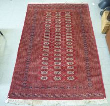 A Bokhara rug, decorated with three columns of twenty guls, on a red ground  50" x 90"