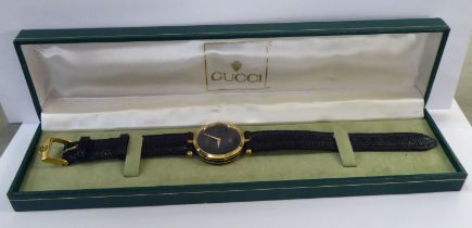 A ladies Gucci black and yellow metal cased wristwatch, on a dedicated black lizard leather strap