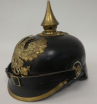 A German black hide and brass mounted pickelhaube with a liner (Please Note: this lot is subject