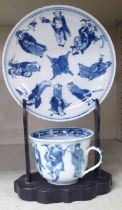 An 18thC Chinese porcelain cup and saucer, decorated with figures, in blue and white, bearing a four