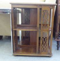 An early 20thC crossbanded and string inlaid mahogany two tier bookcase with fret carved panels,