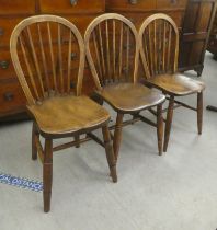 A matched set of three late 19thC beech and elm framed, hoop and spindle back Windsor dining