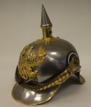 A German polished steel and brass mounted pickelhaube with a liner (Please Note: this lot is subject
