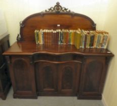 A mid Victorian mahogany inverted breakfront sideboard with a carved, D-shaped upstand, over a