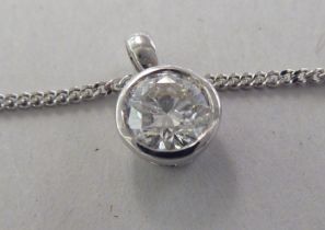 A white gold pendant, set with a single diamond, on a fine neckchain and ring bolt clasp  stamped