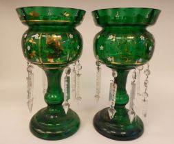 A pair of late 19thC emerald green glass lustre vases with overpainted enamelled and gilt