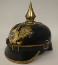 A German black hide and brass mounted pickelhaube with a liner (Please Note: this lot is subject