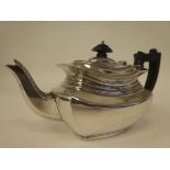 An Edwardian bachelors silver teapot of panelled, oval form with a swept spout, insulated handle and