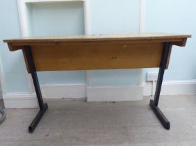 A mid 20thC two person pine desk with two hinged compartments, raised on cast metal legs  27"h  44"w