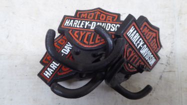 A set of three cast iron, twin handled coat hooks, branded for 'Harley Davidson'  each 4"w