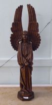 A 20thC carved oak figure, a standing angel with outspread wings, on an octagonal plinth  29"h