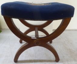 An early 20thC mahogany framed dressing table stool with a concave, tapestry, stud upholstered