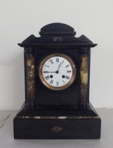 A late Victorian black slate mantel clock of architectural form; the 8 day movement faced by a Roman