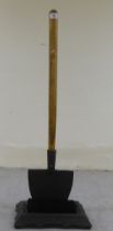 A modern boot scraper, the cast iron brush base surmounted by a wooden handled spade  33"h