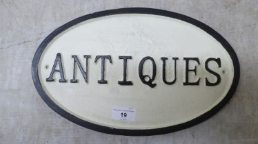 A painted cast iron sign 'Antiques'  13"dia