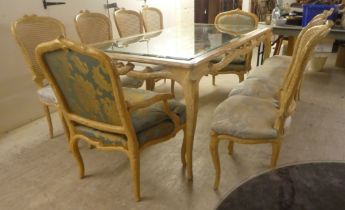 A modern French hunting lodge style, naturally carved, bleached light oak dining table with a