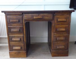A 1930s oak veneered one piece, nine drawer twin pedestal desk, on a plinth  30"h  42"w