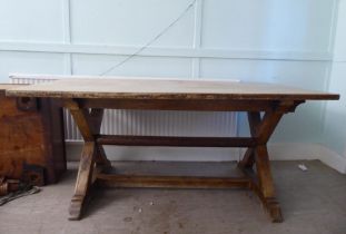 A late 19thC oak refectory table, the planked top over a pair of crossover supports and