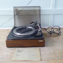 A Garrard 60 MKII record deck, in a teak effect and tinted plastic hinged case  14"w