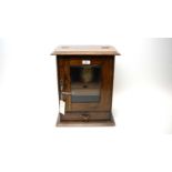An early 20th century stained oak smokers cabinet,