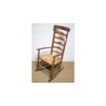 A rustic oak ladderback rocking chair.