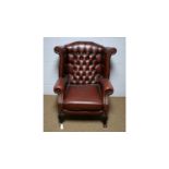 A Victorian-style buttoned and wing back armchair.