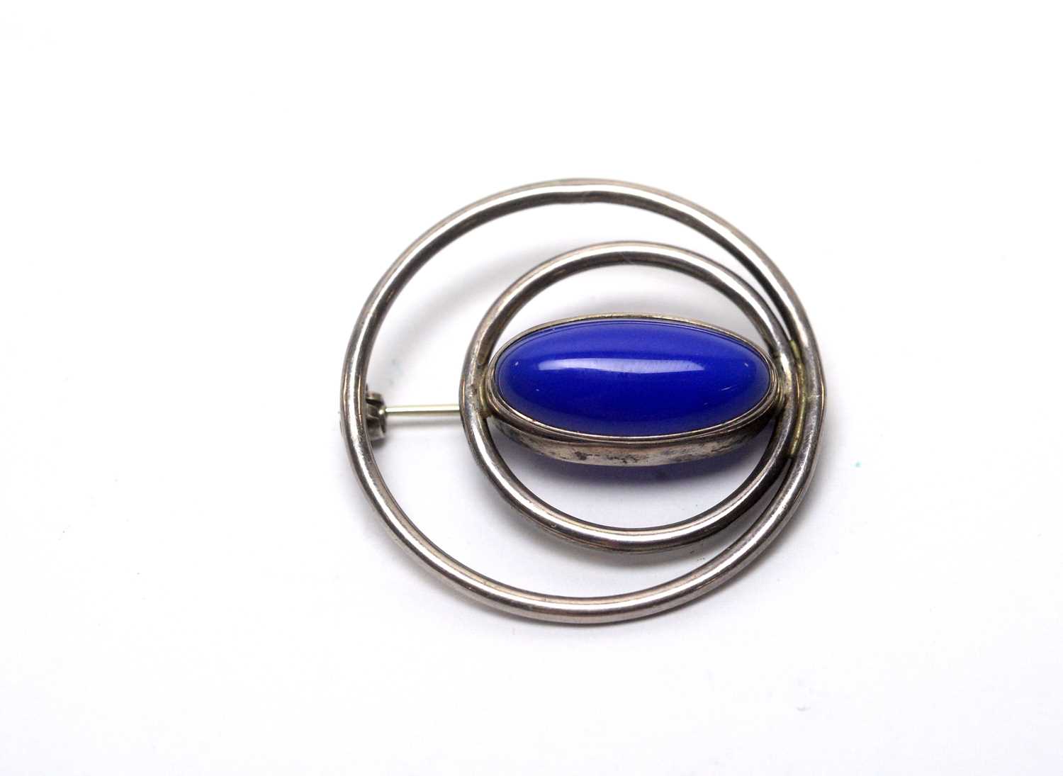 A silver and blue stone cabochon brooch, by Ola Gorie.