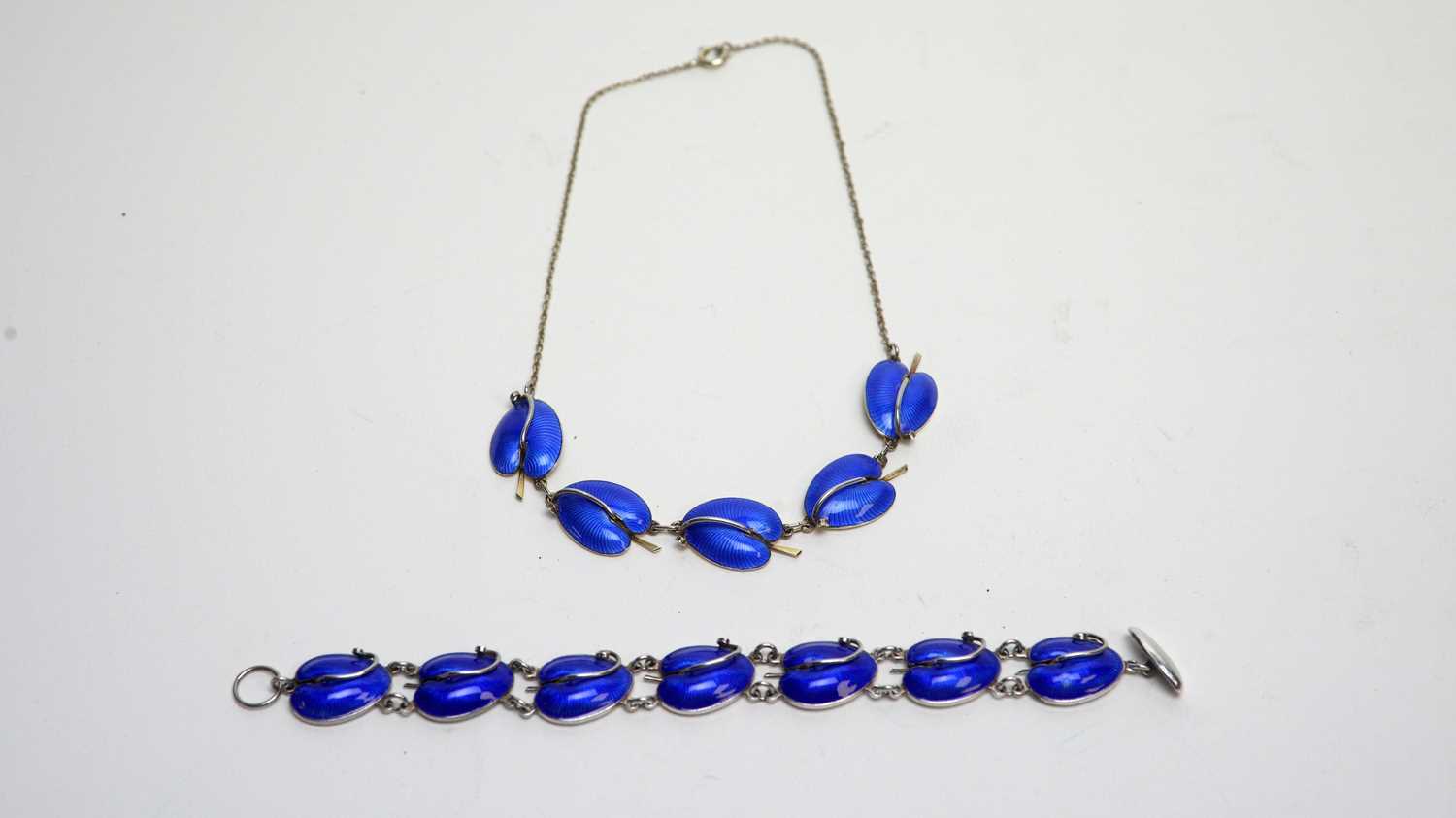 A silver and blue enamel bracelet and necklace.