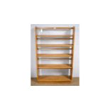 Ercol: a light elm graduated open bookcase.