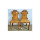 A pair of Victorian carved oak hall chairs.