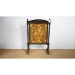 A Victorian carved and ebonised firescreen.