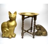 A gilt-painted decorative cat figure; a pair of pig figures; and a brass tray table.