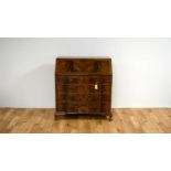 A mid-20th Century fiddleback and flame mahogany breakfront bureau