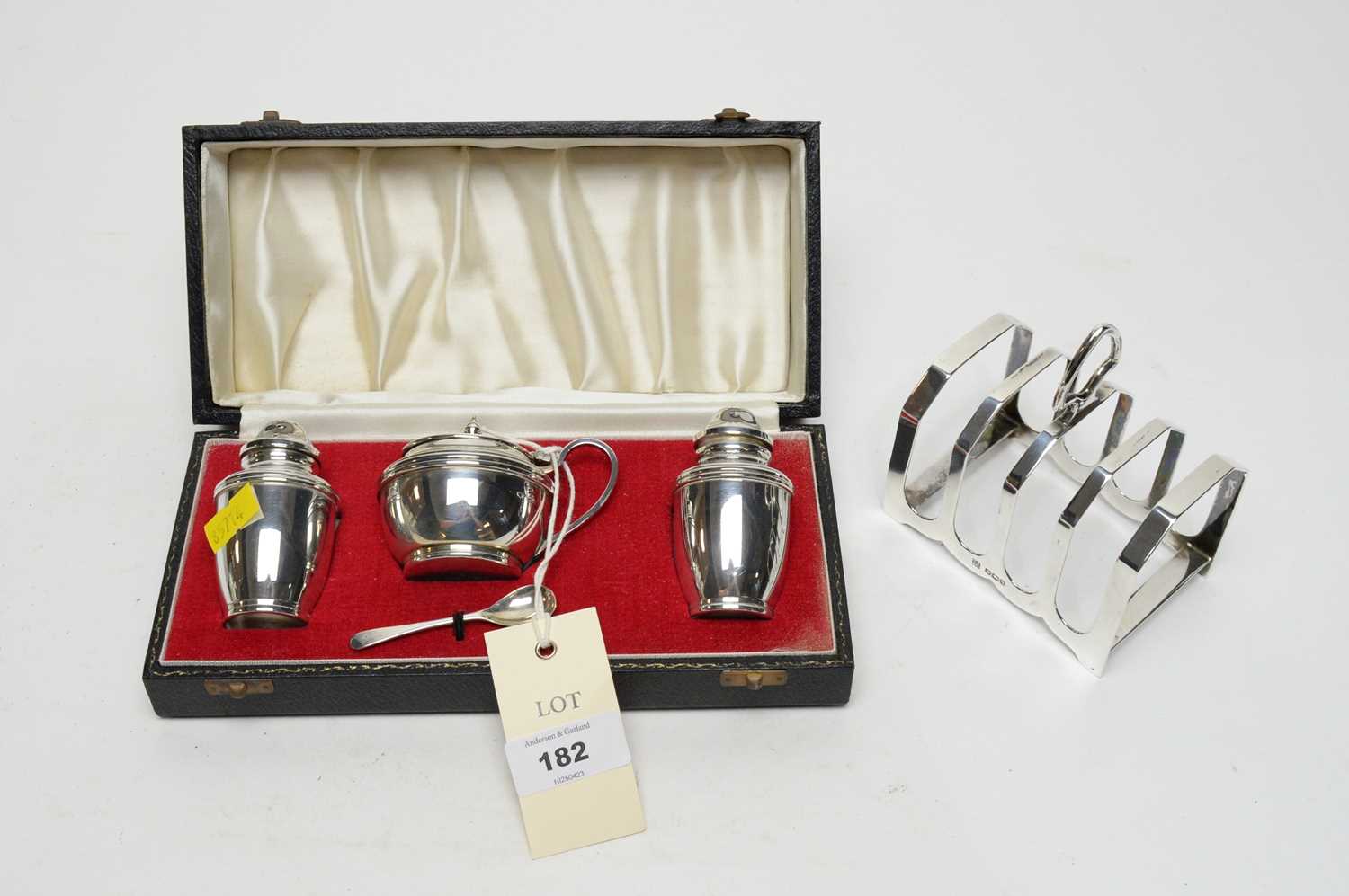 A three piece silver condiment set and a silver five bar toast rack