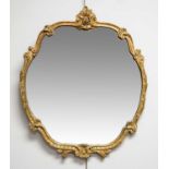 A reproduction Baroque style gilt wall mirror, the shaped frame with shell motifs