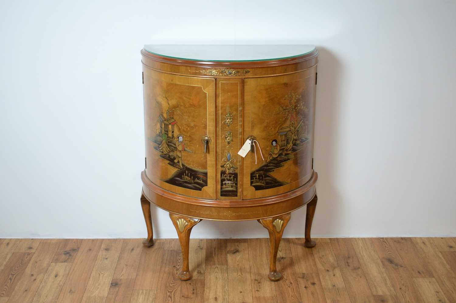 A 20th Century demi lune walnut cabinet with chinoiserie detailing