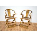 A pair of Chinese hardwood and metal mounted folding hunting chairs