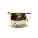 An Arts and Crafts silver cream jug, by Barker Brothers,