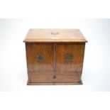 A Victorian oak stationary box, with twin panel doors over frieze drawer