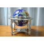 A specimen stone table globe, raised over a silver plated stand with compass set undertier.