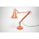 A vintage Anglepoise desk lamp, in orange, wired for electricity