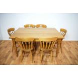 A 20th Century oak topped dining table of rectangular form with six dining chairs
