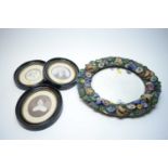 A floral encrusted circular wall mirror