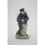 A Royal Copenhagen figure of a boy with dog.