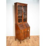An early 20th Century mahogany bureau bookcase by Harrods of London