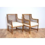 A pair of early 20th Century walnut bergere rattan armchairs