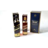 Three bottles of scotch whiskey - Johnnie Walker black, blue & red.